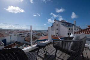 a balcony with chairs and a view of a city at Reserva FLH Hotels Ericeira in Ericeira