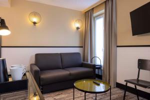 a living room with a couch and a table at Hotel de l'Aqueduc in Paris +97 photos