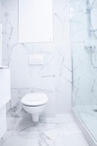 biała łazienka z toaletą i prysznicem w obiekcie Home in Paris - Paris East w Paryżu