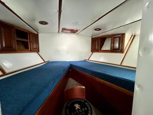 ein kleines Zimmer mit einem blauen Bett auf einem Boot in der Unterkunft salidas en barco in Premiá de Mar