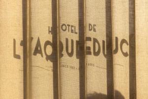 a shadow of a sign on the side of a building at Hotel de l'Aqueduc in Paris