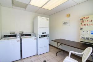 a kitchen with a refrigerator, stove, microwave and a table at Motel 6 Old town Scottsdale Fashion Square in Scottsdale