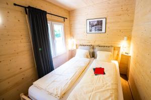 Habitación de madera con 2 camas individuales y ventana en Camping Jungfrau en Lauterbrunnen