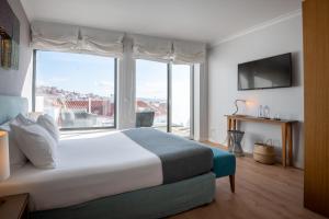 a bedroom with a large bed and a large window at Reserva FLH Hotels Ericeira in Ericeira