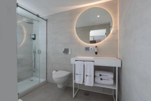 a bathroom with a toilet and a sink and a mirror at Reserva FLH Hotels Ericeira in Ericeira