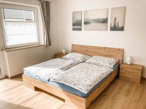sypialnia z drewnianym łóżkiem i oknem w obiekcie Ferienwohnung Olympia Axams w mieście Innsbruck