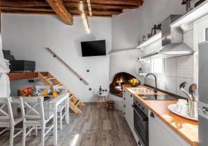 a kitchen with white appliances and a pizza oven at Lotza Traditional House Salakos in Sálakos