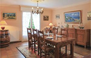 comedor con mesa y barril de vino en Cozy Home In Ploneour-lanvern With Kitchen, en Plonéour-Lanvern