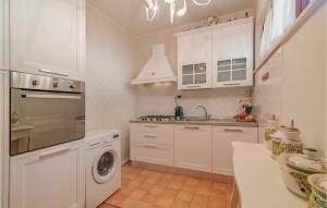 a kitchen with white cabinets and a washer at Villa Silvana in Pesaro
