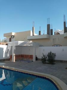 a swimming pool in front of a house at Maryland Guest House in Luxor