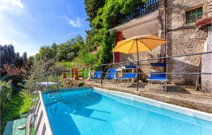 a swimming pool with a yellow umbrella and blue chairs at Casa Firma in Casoli