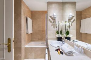 a bathroom with a tub, sink and mirror at Emperador in Madrid