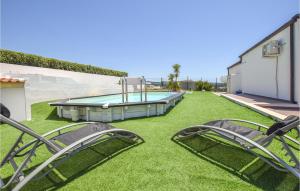zwei Stühle auf dem Rasen neben einem Swimmingpool in der Unterkunft Casa Del Mar in Marina di Ragusa