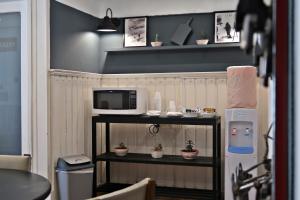 a small shelf with a microwave and potted plants on it at Hotel Nordico in San Carlos de Bariloche