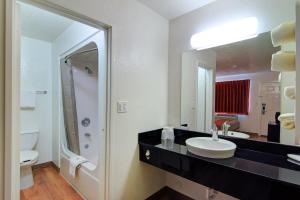 a bathroom with a sink and a toilet and a mirror at Motel 6 Old town Scottsdale Fashion Square in Scottsdale