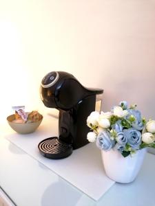 a coffee maker and a vase of flowers on a counter at Romebest in Rome