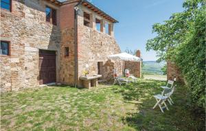 a stone house with a table and chairs in the yard at Schivanoia 2 in Bagno Vignoni