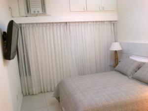 Habitación pequeña con cama y cortina en Apartamento em Ondina, en Salvador 2 fotos más