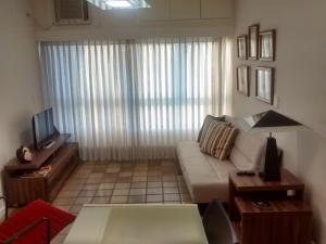 a living room with a couch and a television at Apartamento em Ondina in Salvador