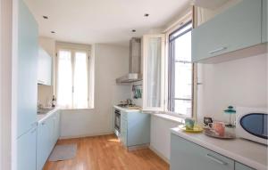 a kitchen with white cabinets and windows and wooden floors at Villino Anna in Viareggio +10 photos