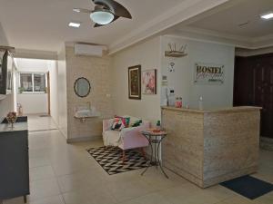 a waiting room with a couch and a counter at Pousada Della Nonna in Presidente Prudente