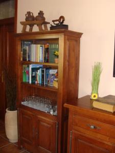 a book shelf with glasses in it next to a table at Alojamiento Rural La Henera in San Juan de Ortega