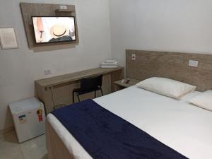 a bedroom with a bed and a desk and a mirror at Pousada Della Nonna in Presidente Prudente +9 photos