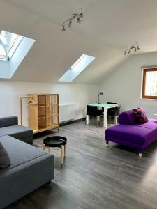 a living room with a purple couch and a table at Loft am Hauptplatz in Gloggnitz