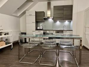 a kitchen with a glass table and some chairs at Loft am Hauptplatz in Gloggnitz