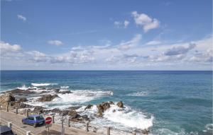 a blue car parked next to the ocean at Stunning Home In Sangineto Lido in Belvedere Marittimo