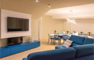 ein Wohnzimmer mit einem blauen Sofa und einem TV in der Unterkunft Pet Friendly Home In Sangineto Lido With Kitchen in Belvedere Marittimo