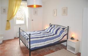 Schlafzimmer mit einem Bett mit blauen und weißen Streifen in der Unterkunft 2 Bedroom Nice Home In Saint-gervais-sur-mare in Saint-Gervais-sur-Mare
