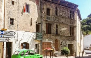 einem grünen Auto, das vor einem Gebäude parkt in der Unterkunft 2 Bedroom Nice Home In Saint-gervais-sur-mare in Saint-Gervais-sur-Mare