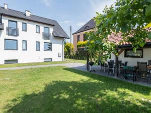 a yard with chairs and a table and a building at Apartamenty ZATOR20 2 min od Energylandii in Zator