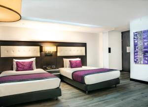 a hotel room with two beds with purple pillows at Hotel City Bog Expo Museo in Bogotá +23 photos
