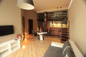 a living room with a couch and a dining room at Loft Niezapominajka w Tobaco Park in Łódź