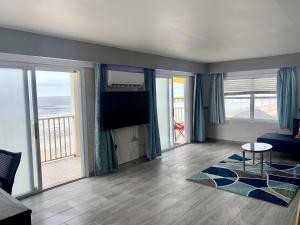 uma sala de estar com uma televisão de ecrã plano e um sofá em Sand Castle Motel em Daytona Beach Shores