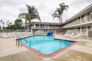 Una piscina en un hotel con sillas y palmeras. en Motel 6-Camarillo, CA, en Camarillo
