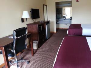 a hotel room with a desk and a bed and a desk at Americas Best Value Inn Bryant in Bryant
