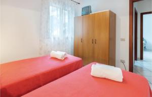 Casa Sole Rosso في بوجيرو: سريرين في غرفة مع أغطية حمراء وكابينة