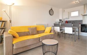a living room with a yellow couch and a kitchen at Stunning Apartment In Ajaccio With Wifi in Ajaccio