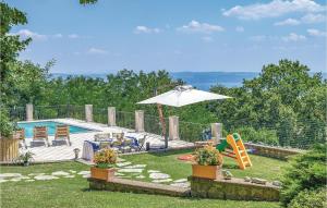 a backyard with a playground with an umbrella and a pool at Villa Agata in Latera
