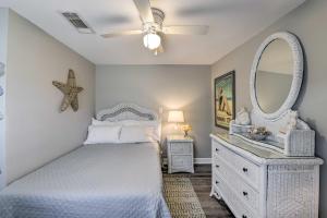 a white bedroom with a bed and a mirror at Cottage with St Andrews Bay Views, Deck and Porch! in Panama City