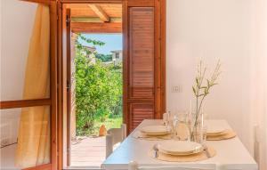 een eetkamer met een witte tafel en een open deur bij Trilo 4 in San Teodoro