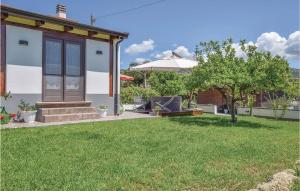 a house with an umbrella and a grass yard at Relax Vacanze Il Mandarino in Castellabate