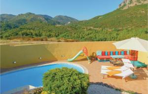 a swimming pool with chairs and an umbrella and a slide at Nice Apartment In Gonnesa With Wifi in Gonnesa