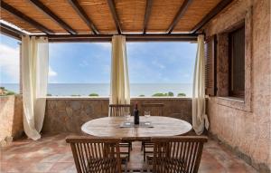 uma mesa e cadeiras num alpendre com vista para o oceano em Villa 6 em Villaputzu