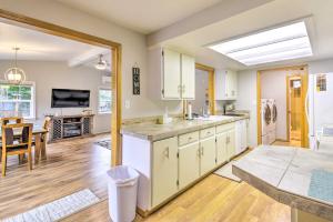 a kitchen with white cabinets and a dining room at Port Angeles Abode with Yard and Guest House! in Port Angeles