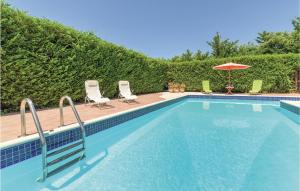 ein Swimmingpool mit zwei Stühlen und einem Sonnenschirm in der Unterkunft Villa Anna in Menfi