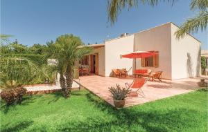ein Haus mit einer Terrasse mit einem Tisch und einem Sonnenschirm in der Unterkunft Villa Anna in Menfi